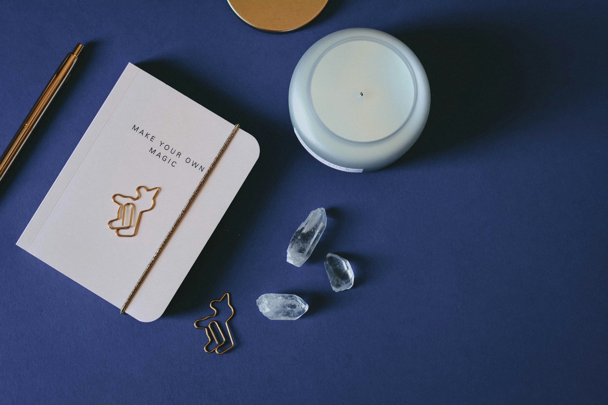 a mindful journal, a candle, and crystals